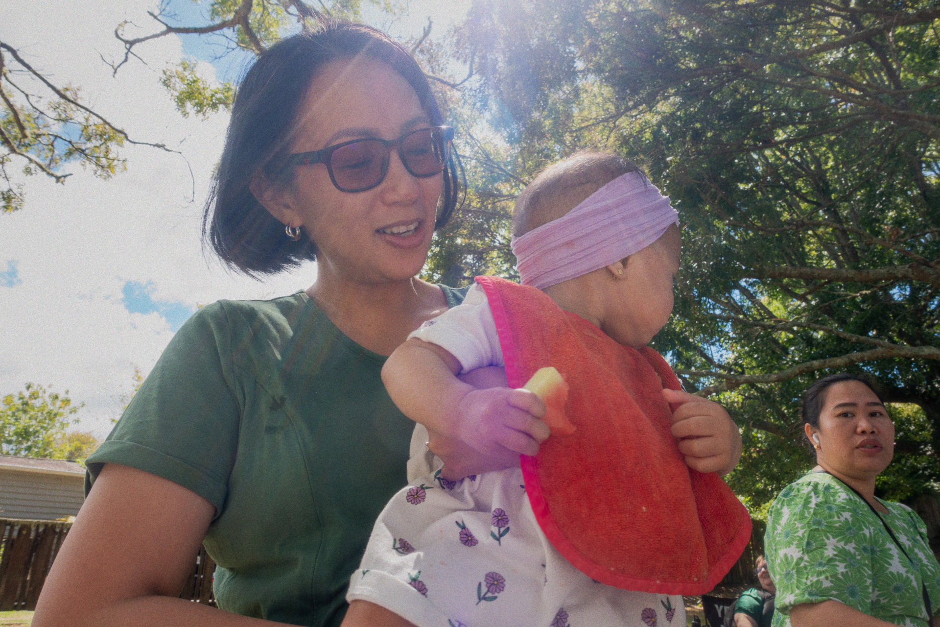 A mother and her baby share a happy moment at a picnic during a church community event.