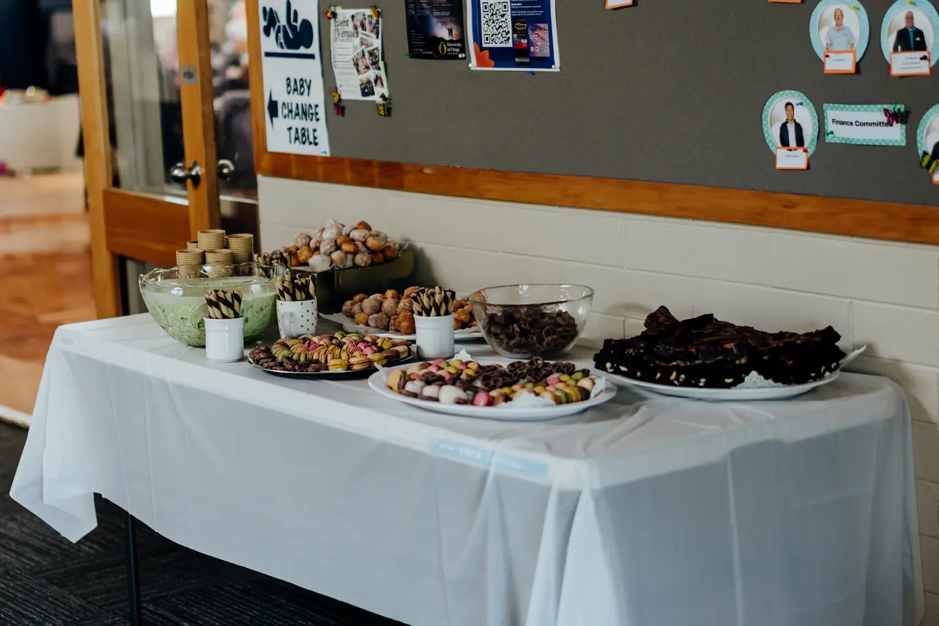 A photo of desserts displayed on a long rectangular table.